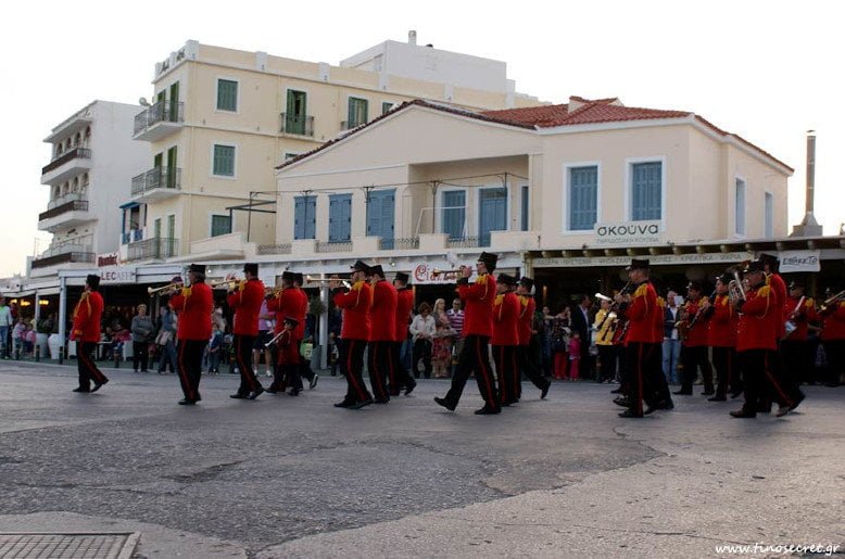 Tinos, Ktikados, The Rite of Love - Gastronomy Tours marching band with red uniforms walking at ‘The Rite of Love’ at Tinos, Ktikados on street
